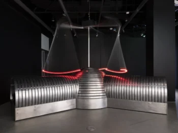 A silver machine in a dark room with red lights.