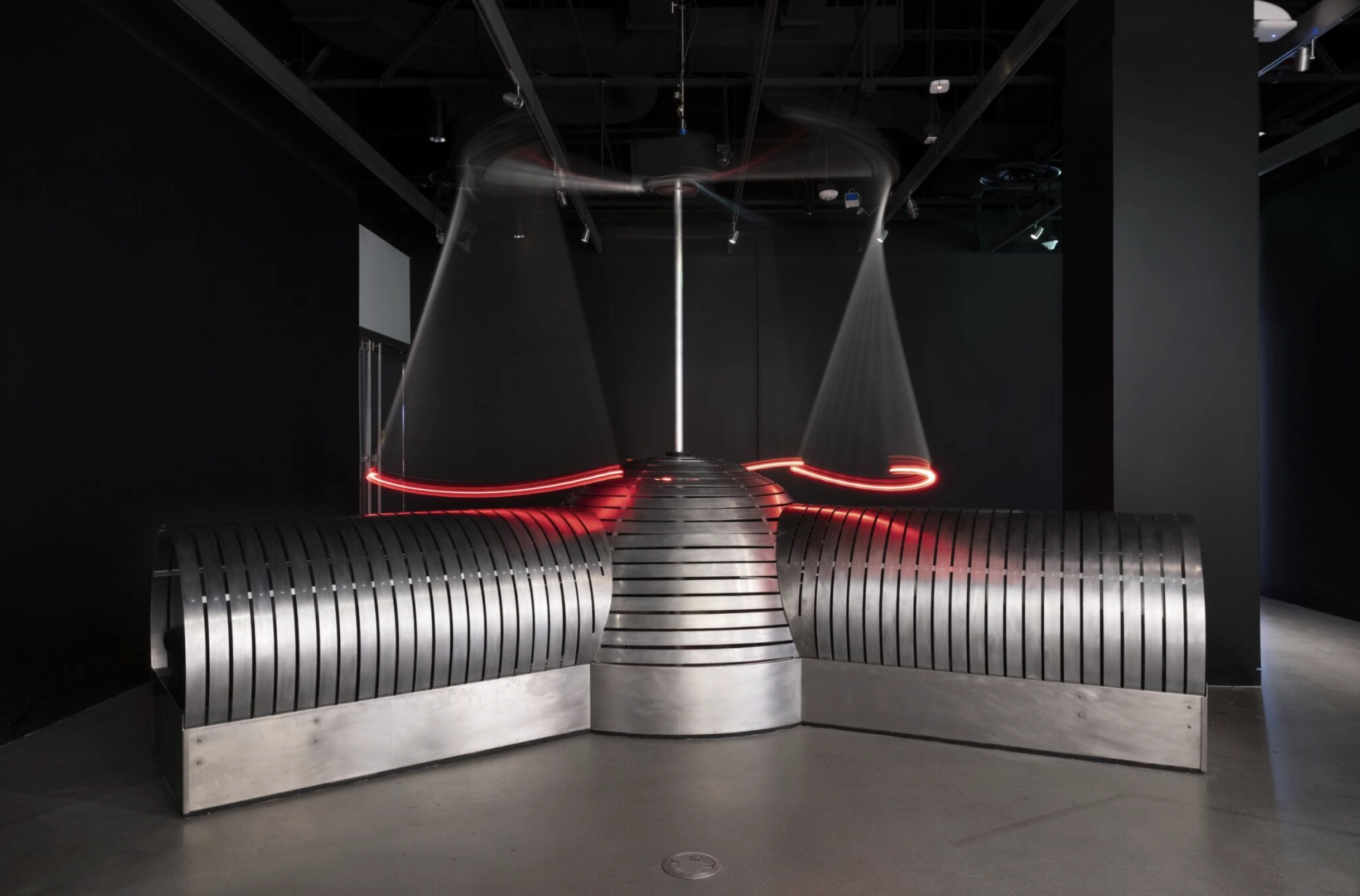 A silver machine in a dark room with red lights.