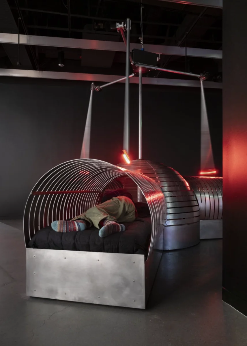 A silver machine in a dark room with red lights.