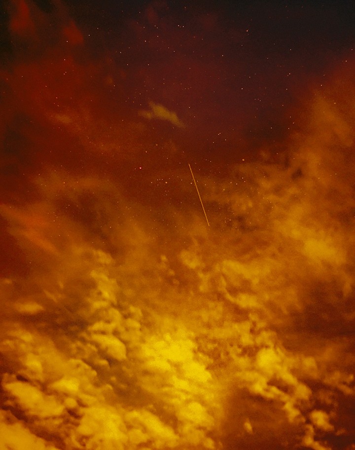A red and yellow sky with clouds and stars.