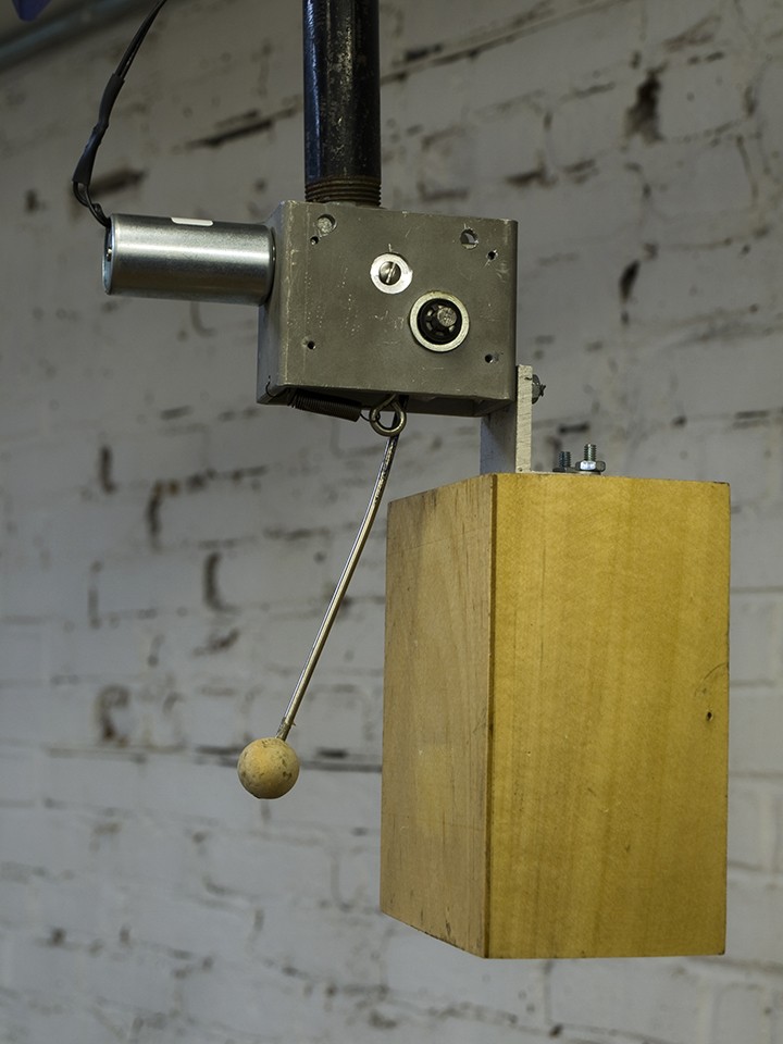 A woodblock and mallet connected to a metal device