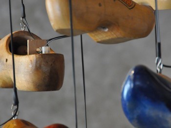 Wooden clogs hanging on wires.